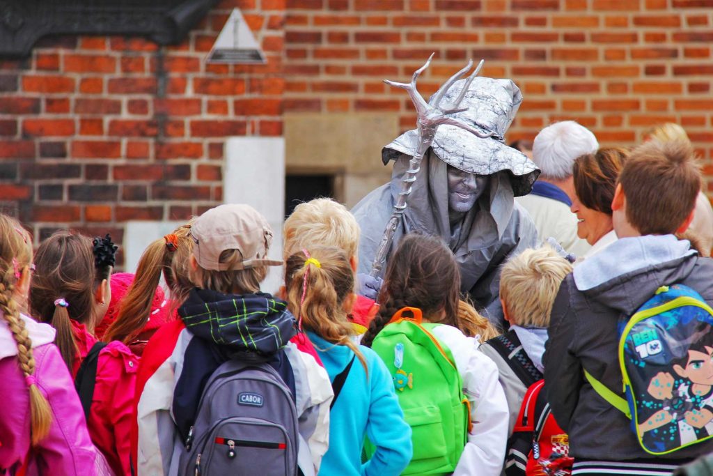 A group of students looking at a statue