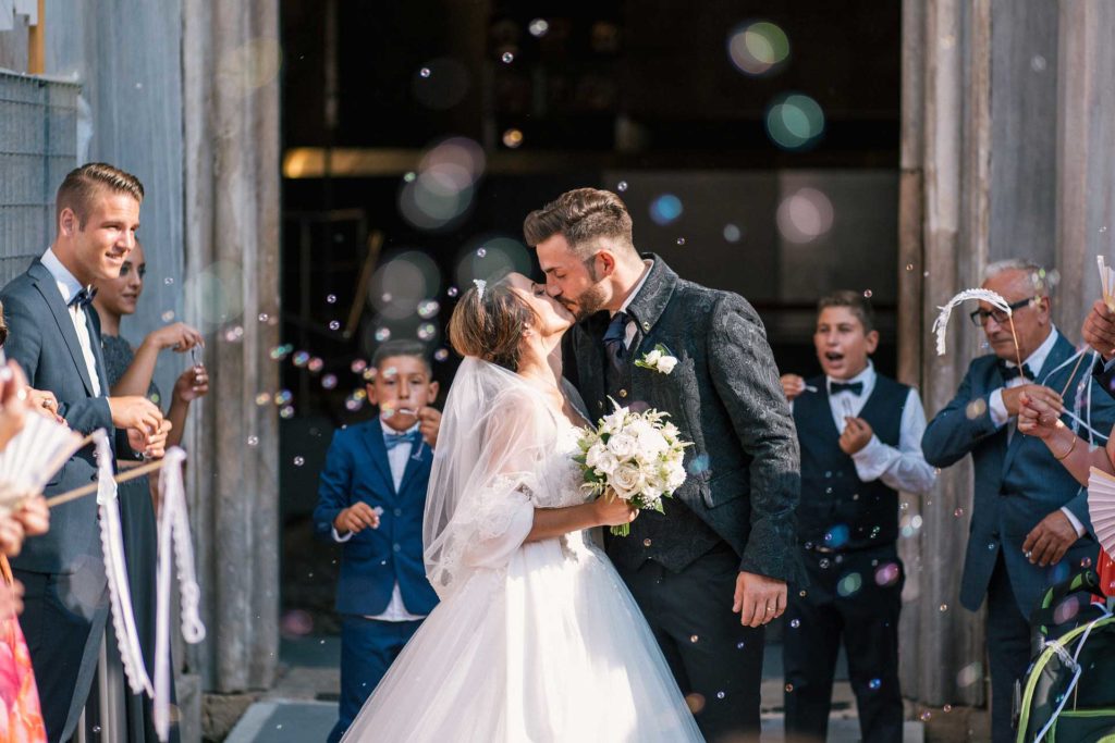 just married couple kissing as they come out of the church